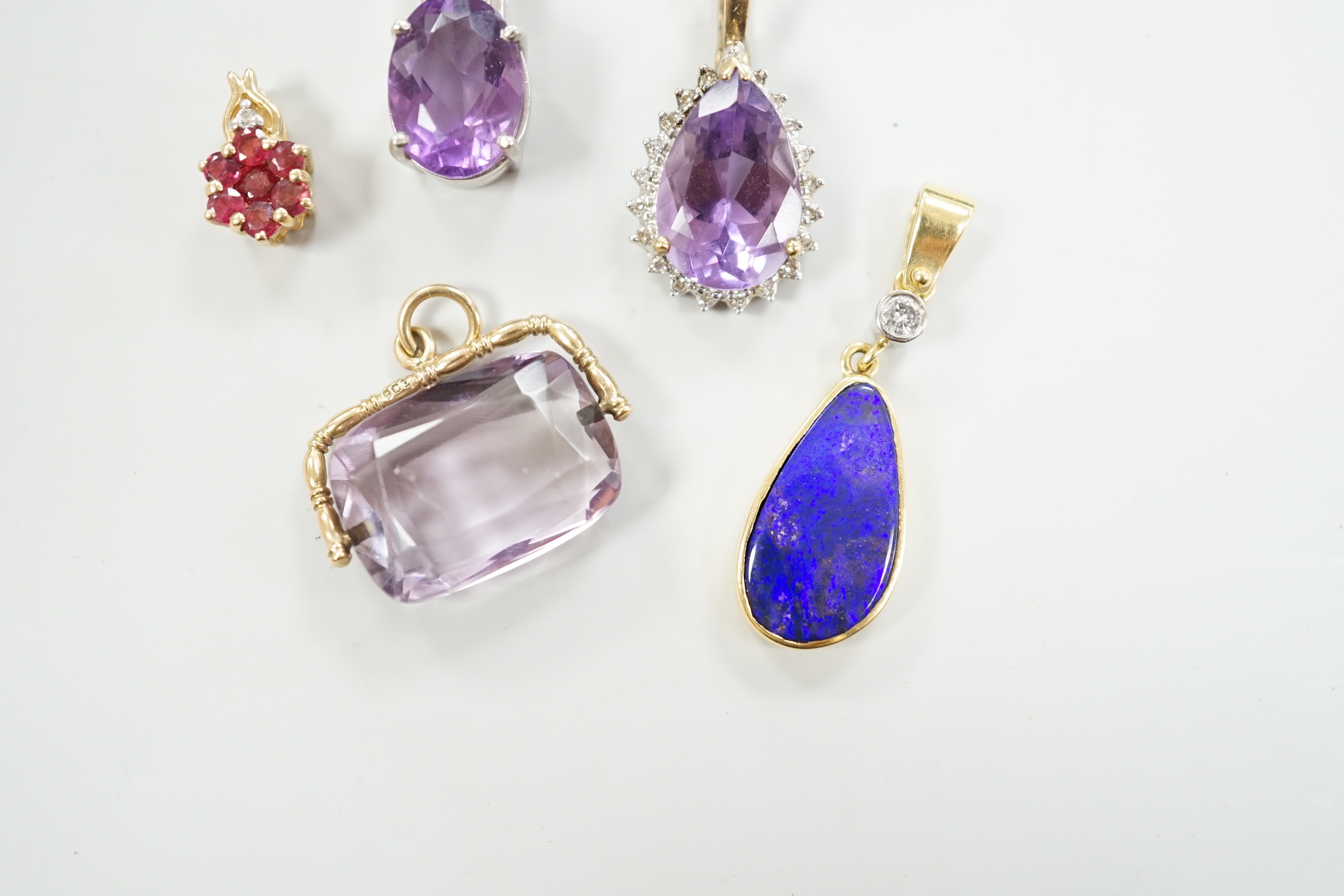 A white metal, stamped PT900, amethyst and diamond cluster set pendant, 18mm, gross weight 5.5 grams and four other pendants including three 9ct and gem set and a yellow metal and simulated opal and diamond, gross 13 gra